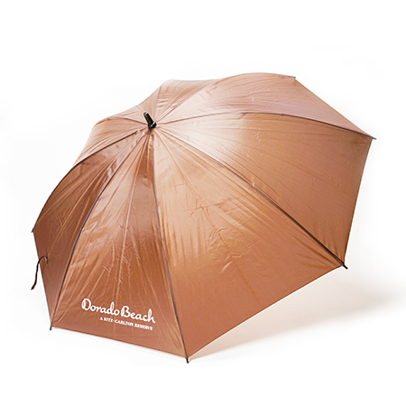 brown promotional umbrella with 'Dorado Beach Ritz Carlton' logo